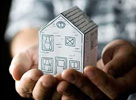 Hands cradling a model of a house
